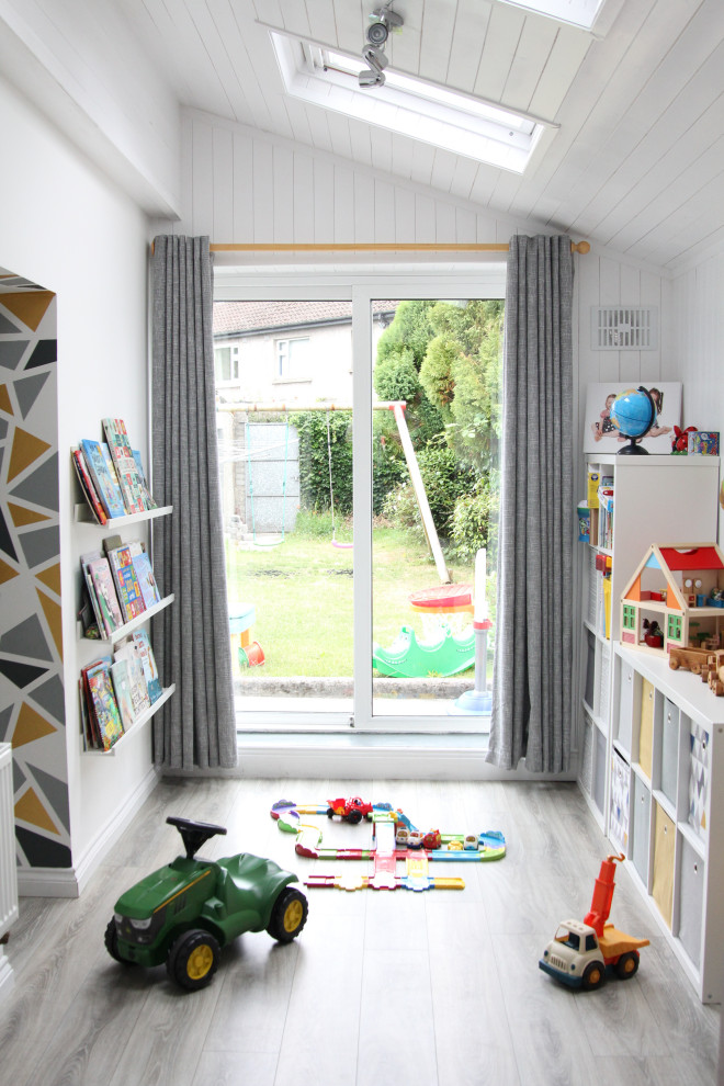 Inspiration för ett litet funkis könsneutralt småbarnsrum kombinerat med lekrum, med vita väggar, laminatgolv och grått golv