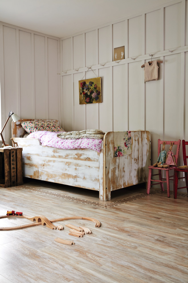 Inspiration for a romantic children’s room for girls in Hertfordshire with grey walls, light hardwood flooring and beige floors.