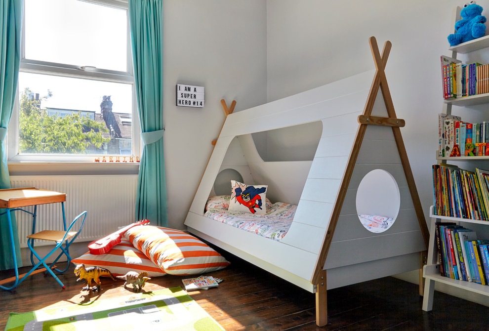 Inredning av ett eklektiskt litet barnrum kombinerat med sovrum, med grå väggar och mörkt trägolv