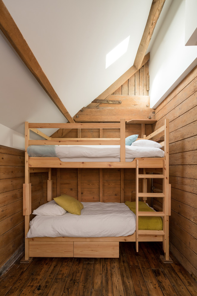 Foto på ett mellanstort rustikt könsneutralt barnrum kombinerat med sovrum och för 4-10-åringar, med mellanmörkt trägolv och brunt golv