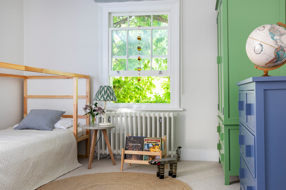На фото: нейтральная детская в стиле неоклассика (современная классика) с серыми стенами, ковровым покрытием, спальным местом и бежевым полом с