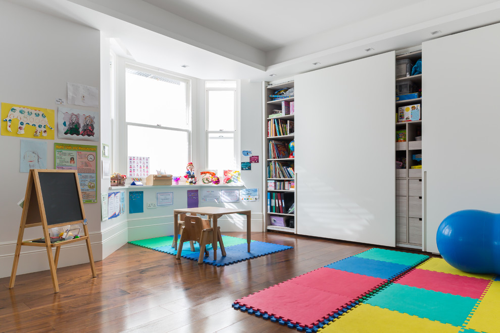 Esempio di una grande cameretta per bambini da 4 a 10 anni minimal con parquet scuro, pavimento marrone e pareti bianche