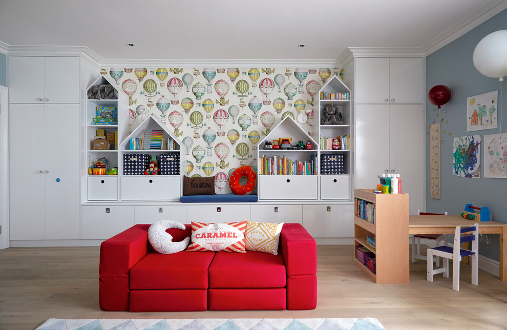 Large contemporary gender neutral kids' bedroom in London with blue walls and light hardwood flooring.