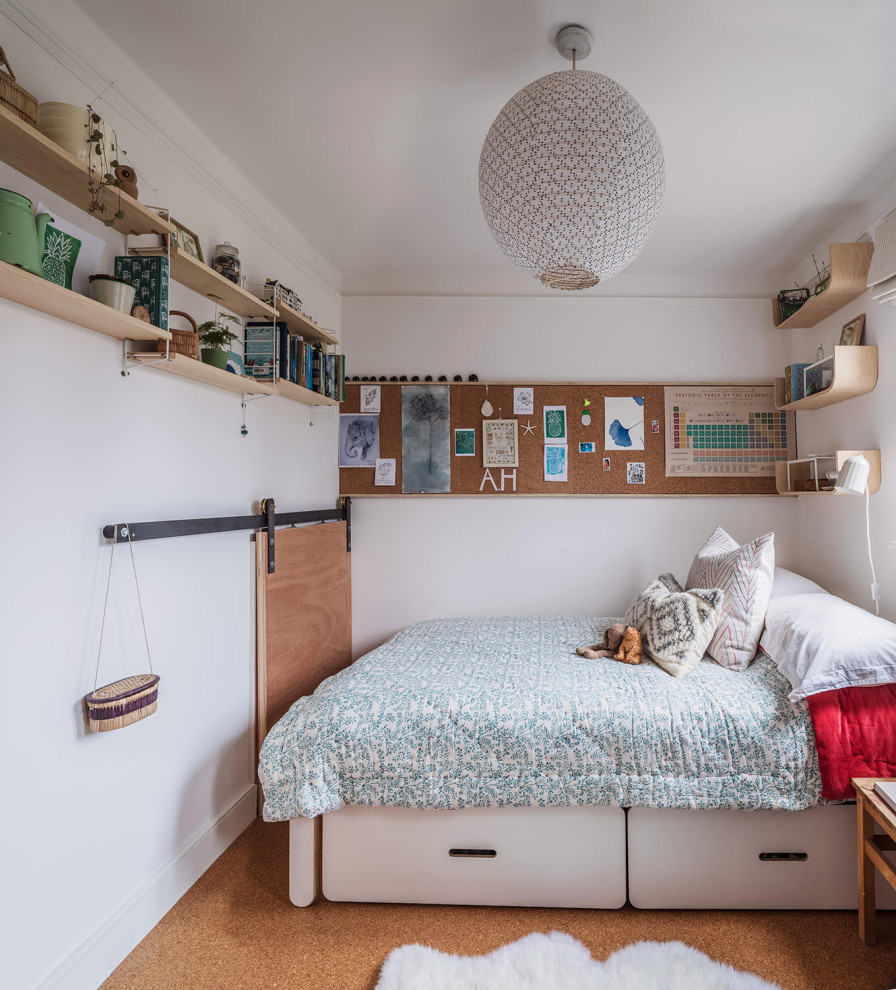 Exempel på ett eklektiskt barnrum kombinerat med sovrum, med vita väggar och korkgolv