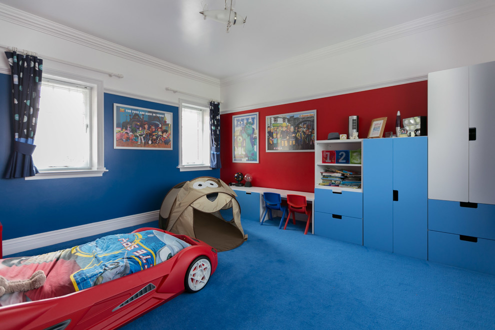 На фото: детская среднего размера в современном стиле с спальным местом, ковровым покрытием, синим полом и разноцветными стенами для ребенка от 1 до 3 лет, мальчика с