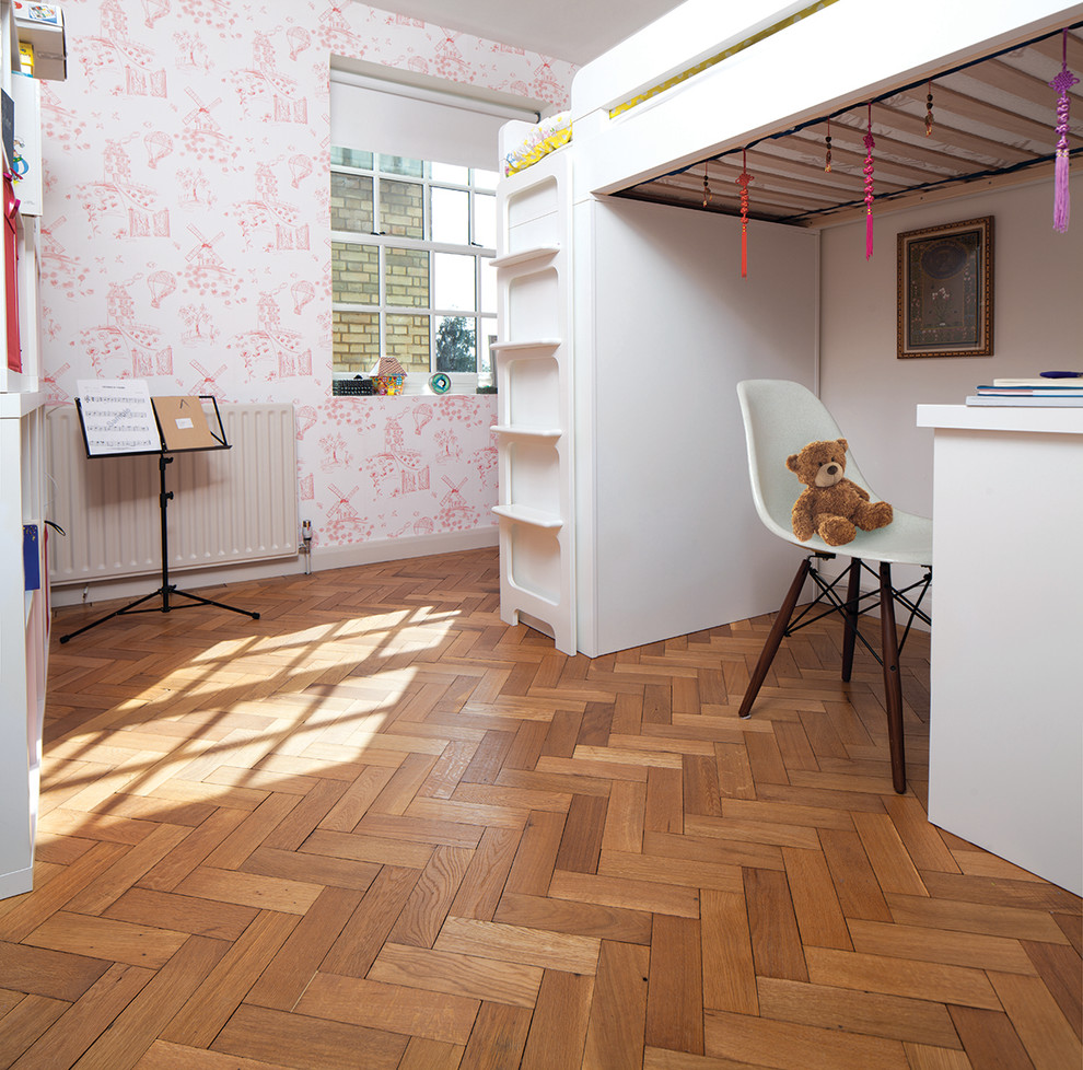 Medium sized modern children’s room in London with pink walls and medium hardwood flooring.