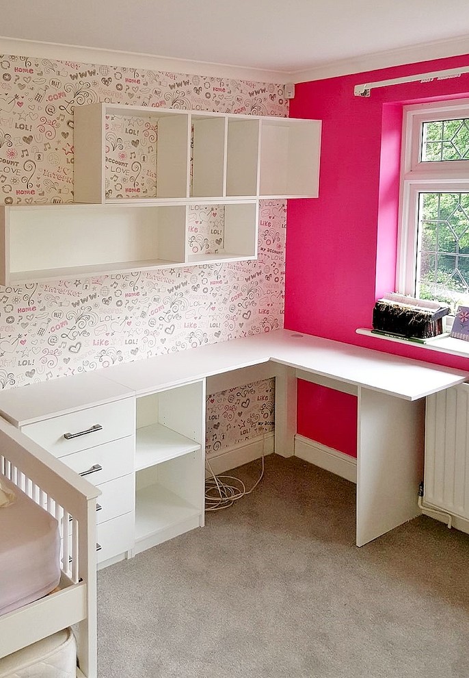 Inredning av ett modernt litet könsneutralt barnrum kombinerat med skrivbord, med flerfärgade väggar, heltäckningsmatta och grått golv