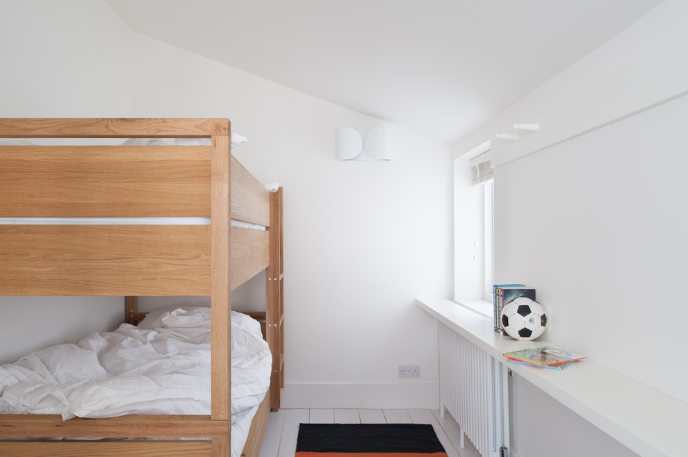 Photo of a medium sized traditional gender neutral children’s room in London with white walls and painted wood flooring.