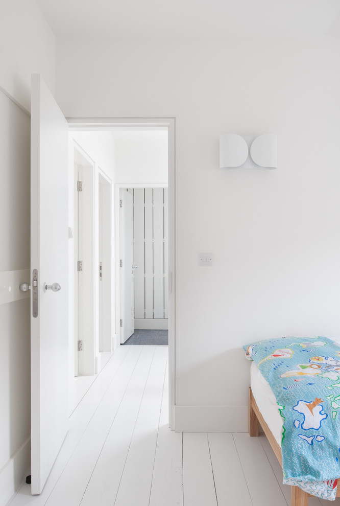 Esempio di una cameretta per bambini da 4 a 10 anni tradizionale di medie dimensioni con pareti bianche e pavimento in legno verniciato