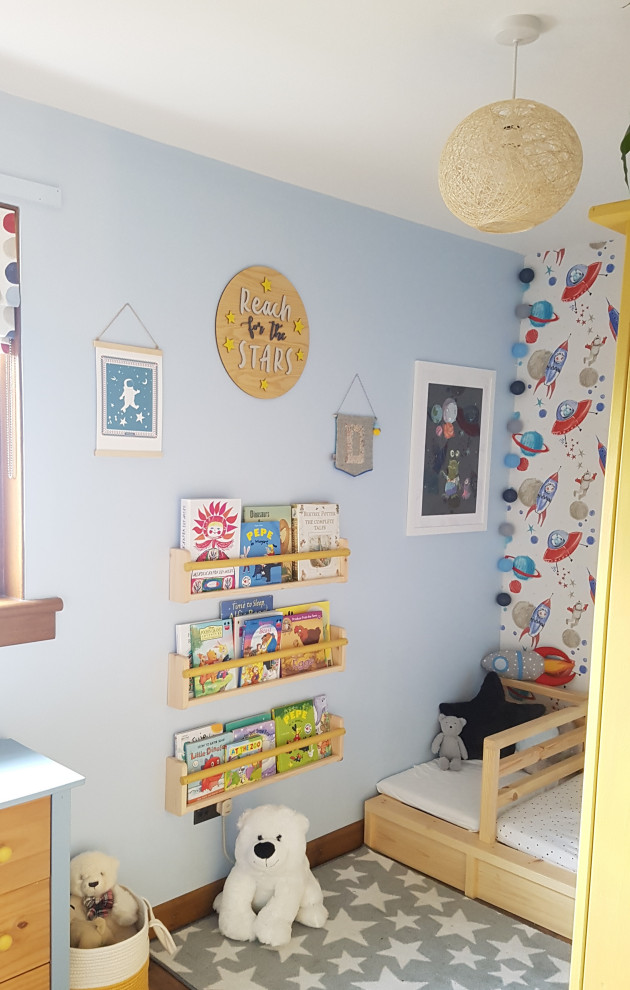 Cette photo montre une chambre d'enfant de 1 à 3 ans éclectique de taille moyenne avec un mur bleu et sol en stratifié.