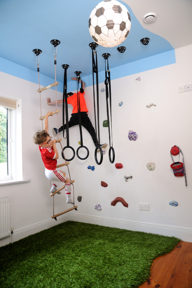 Modernes Kinderzimmer mit Spielecke, weißer Wandfarbe, braunem Holzboden und braunem Boden in Sonstige