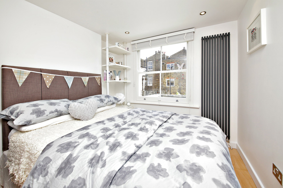 Idee per una camera da letto tradizionale con pareti bianche e parquet chiaro