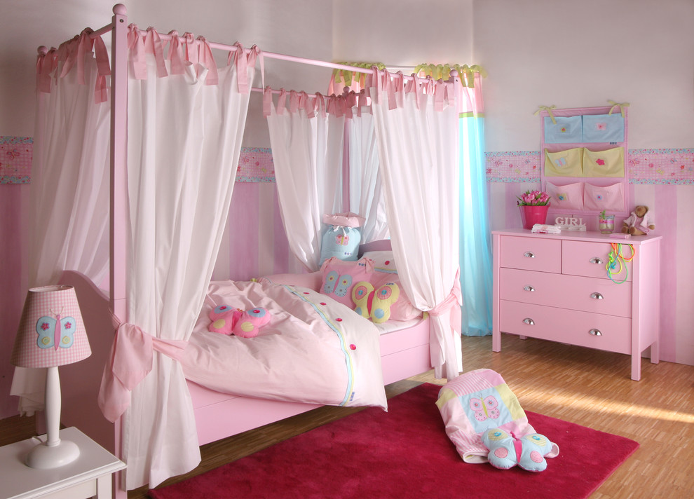 Elegant girl bamboo floor kids' room photo in London with multicolored walls