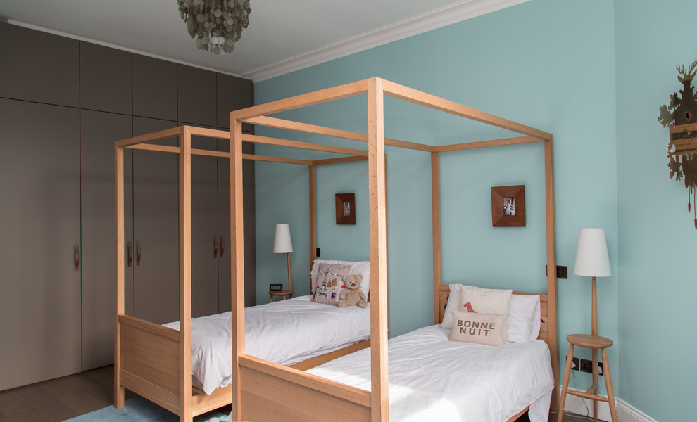Idéer för ett mellanstort modernt könsneutralt barnrum kombinerat med sovrum, med blå väggar, mellanmörkt trägolv och brunt golv