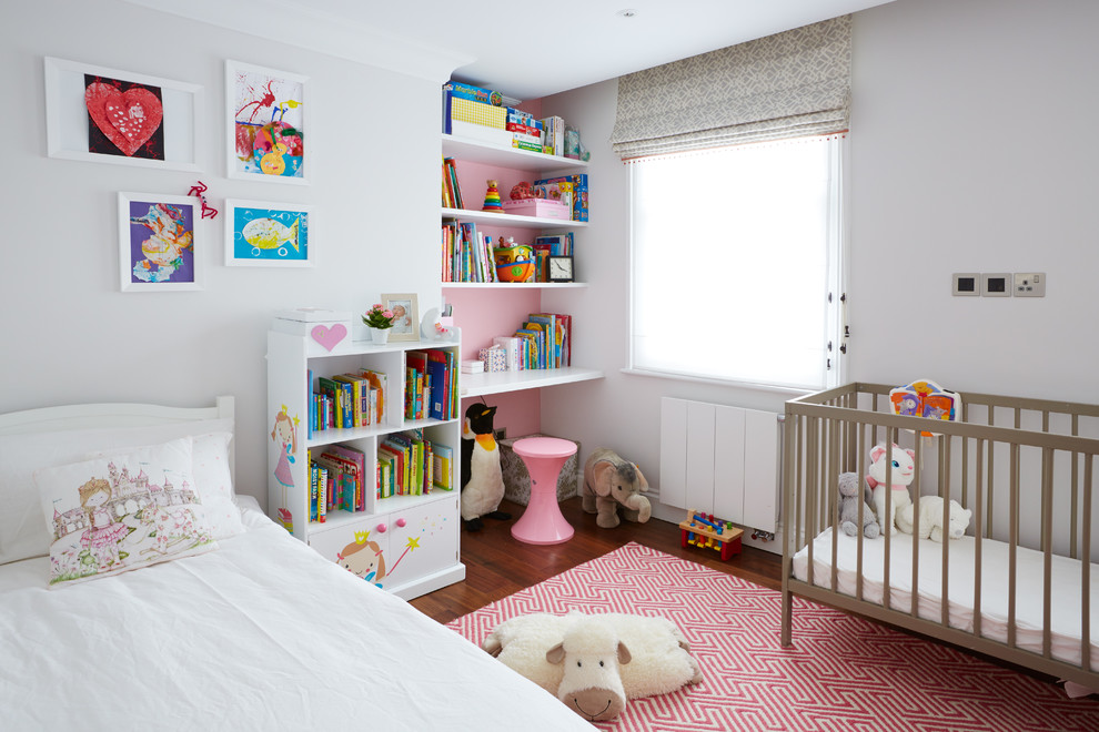 Immagine di una cameretta per bambini da 1 a 3 anni chic di medie dimensioni con pareti bianche e pavimento in legno massello medio