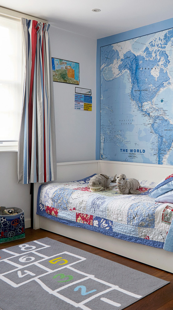 This is an example of a contemporary kids' bedroom for boys in London with blue walls, dark hardwood flooring, brown floors and a feature wall.