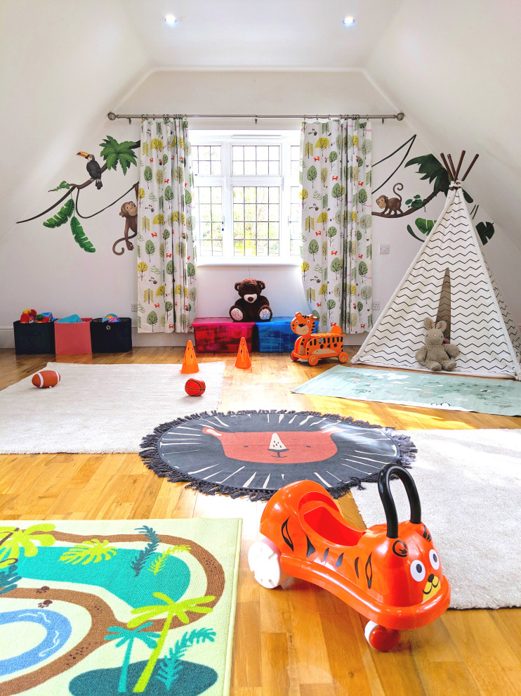 Esempio di una grande cameretta per bambini da 1 a 3 anni eclettica con pareti bianche e pavimento in laminato