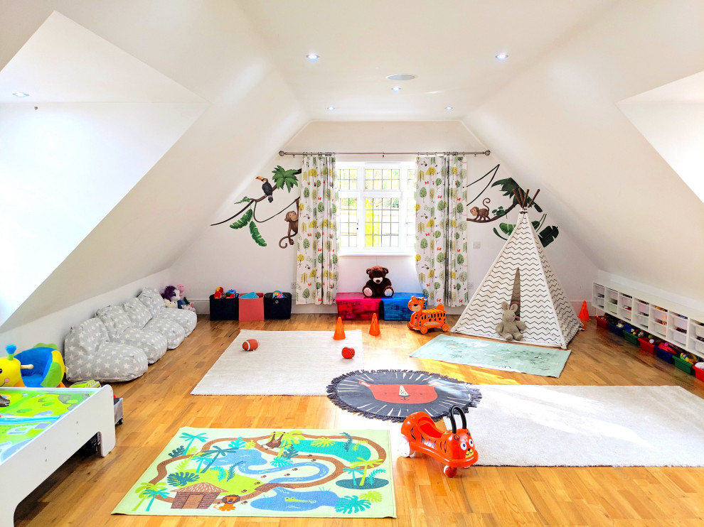 Idee per una grande cameretta per bambini da 1 a 3 anni boho chic con pareti bianche e pavimento in laminato