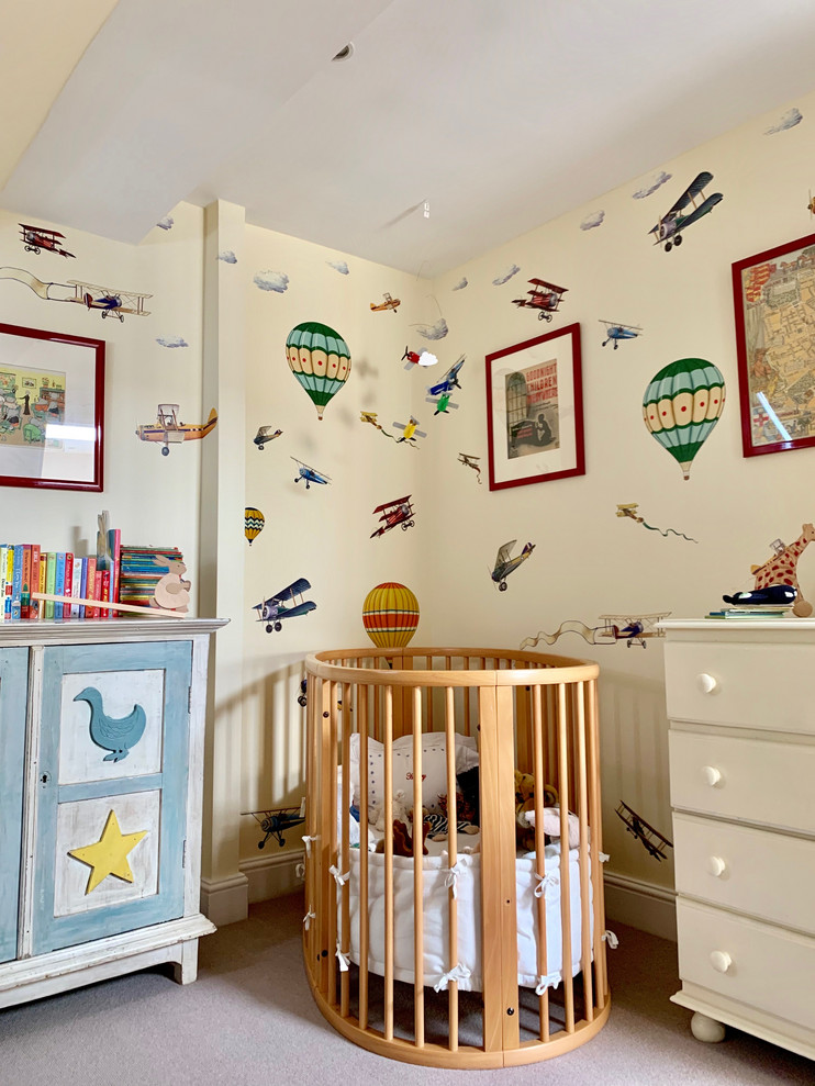 Example of a mid-sized classic gender-neutral carpeted and beige floor nursery design in London with multicolored walls