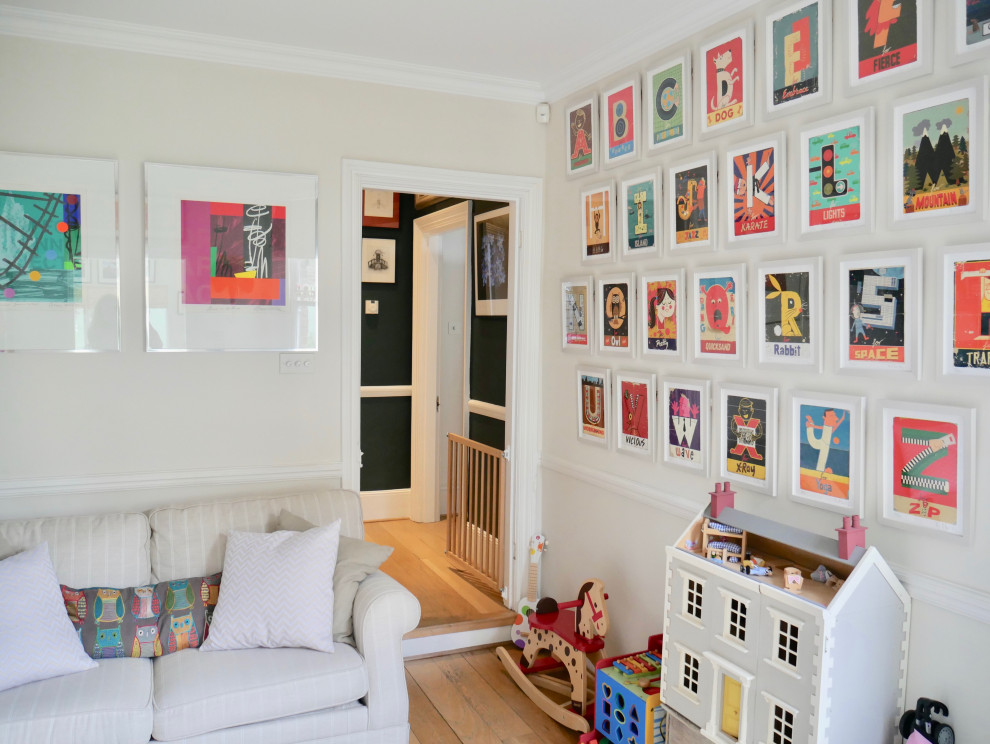 This is an example of a small classic gender neutral kids' bedroom in London with grey walls, light hardwood flooring and brown floors.