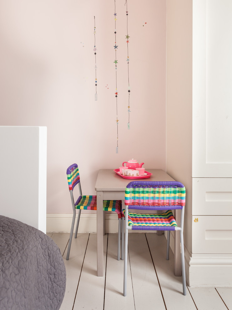 Esempio di una cameretta da bambina contemporanea con pareti rosa e pavimento in legno verniciato