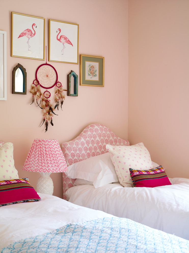 This is an example of a small classic gender neutral children’s room in Other with pink walls.
