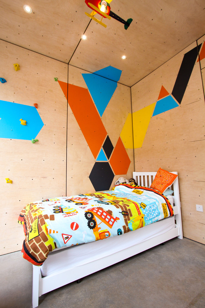 Inredning av ett skandinaviskt mellanstort pojkrum kombinerat med sovrum och för 4-10-åringar, med flerfärgade väggar och betonggolv