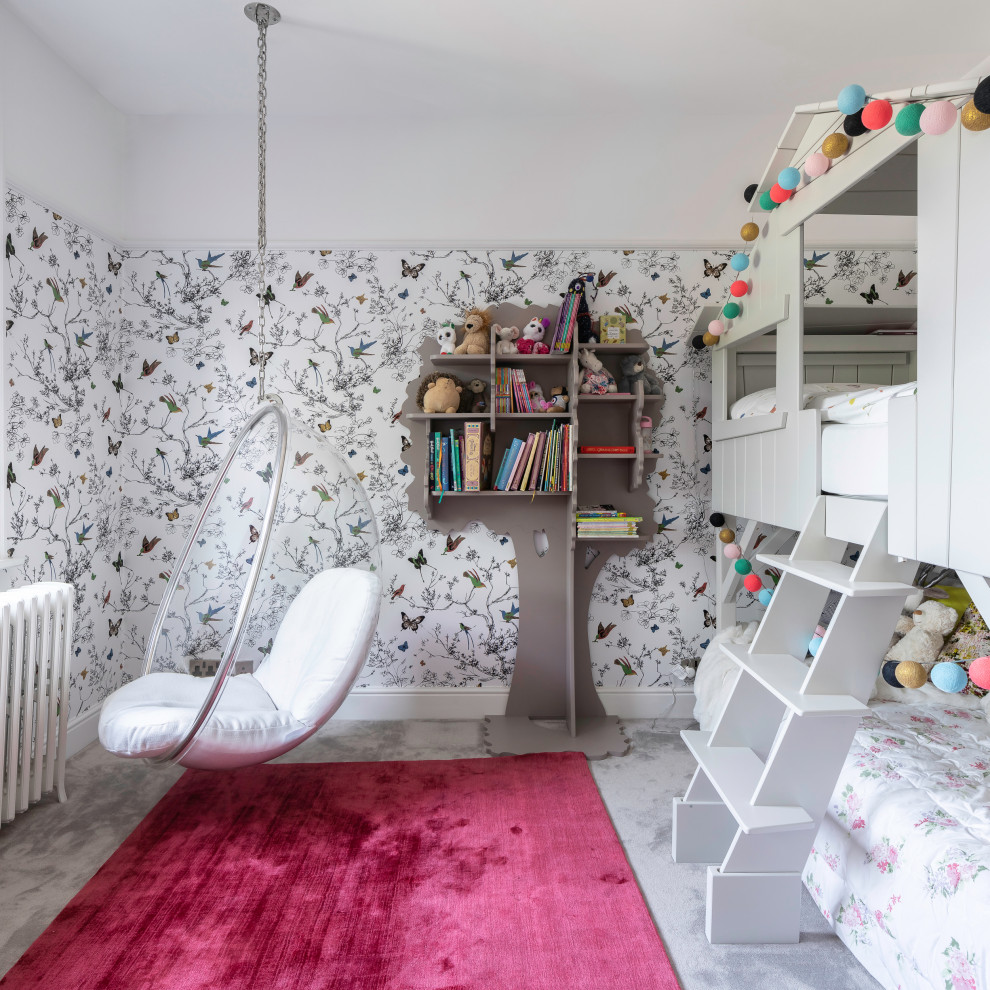 This is an example of a large contemporary children’s room for girls in Hertfordshire with white walls, carpet, grey floors and wallpapered walls.