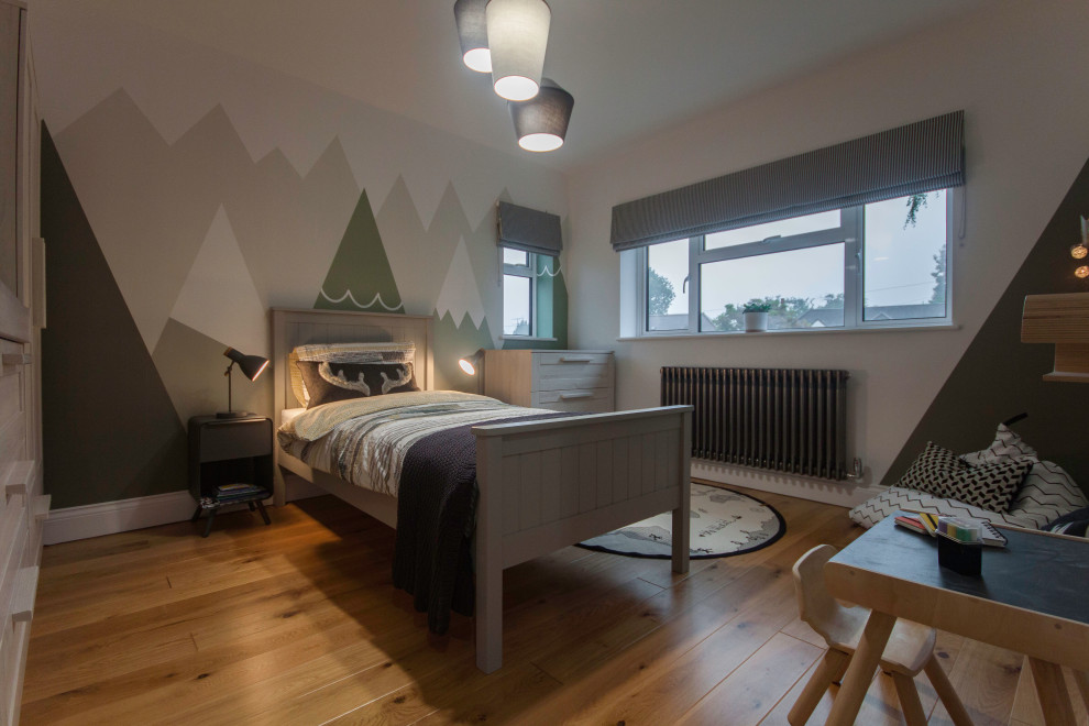This is an example of a medium sized contemporary children’s room for boys in Buckinghamshire with white walls, light hardwood flooring and beige floors.