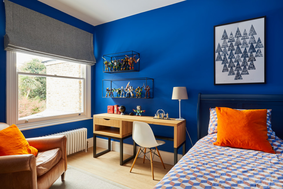 This is an example of a small contemporary children’s room for boys in Surrey with blue walls, light hardwood flooring and brown floors.