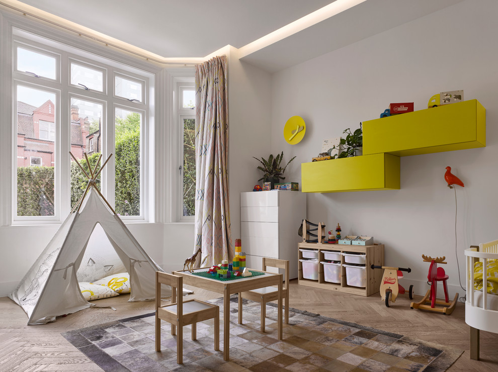 Immagine di una cameretta per bambini design con pareti bianche, parquet chiaro e pavimento beige
