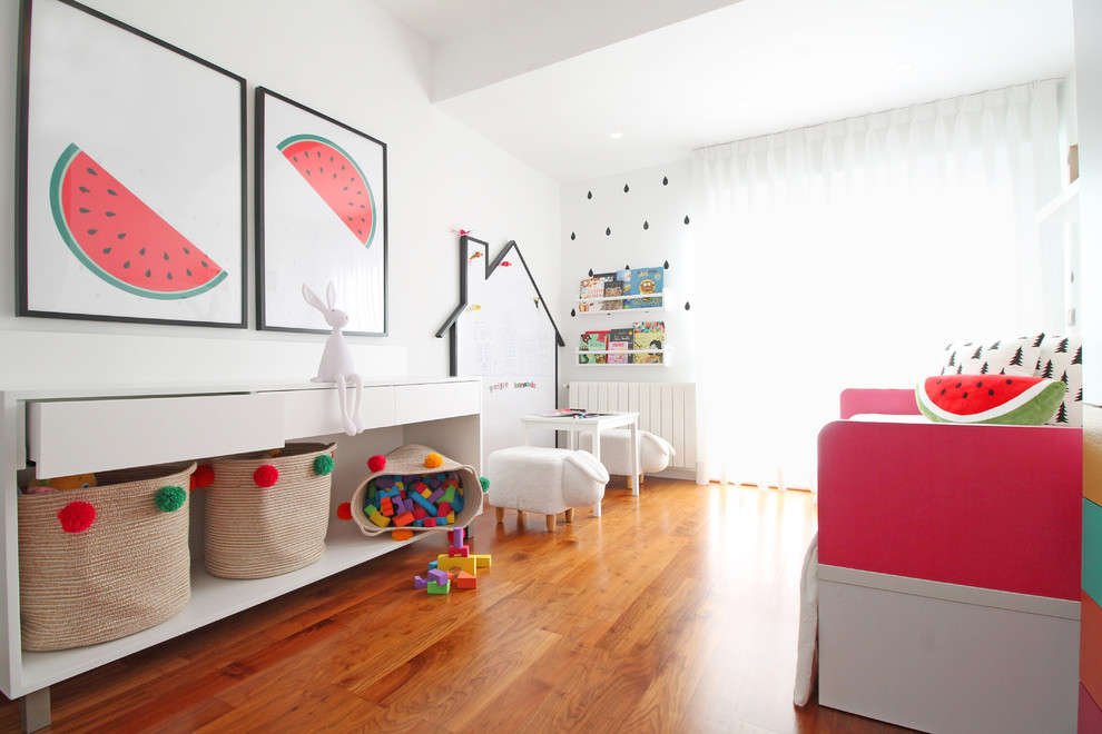 Imagen de dormitorio infantil de 1 a 3 años moderno de tamaño medio con paredes blancas y suelo laminado