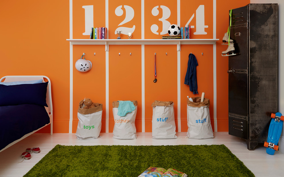 На фото: нейтральная детская среднего размера с спальным местом, оранжевыми стенами и ковровым покрытием для ребенка от 4 до 10 лет