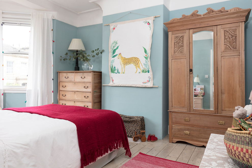 Bild på ett vintage flickrum kombinerat med sovrum, med blå väggar, ljust trägolv och beiget golv