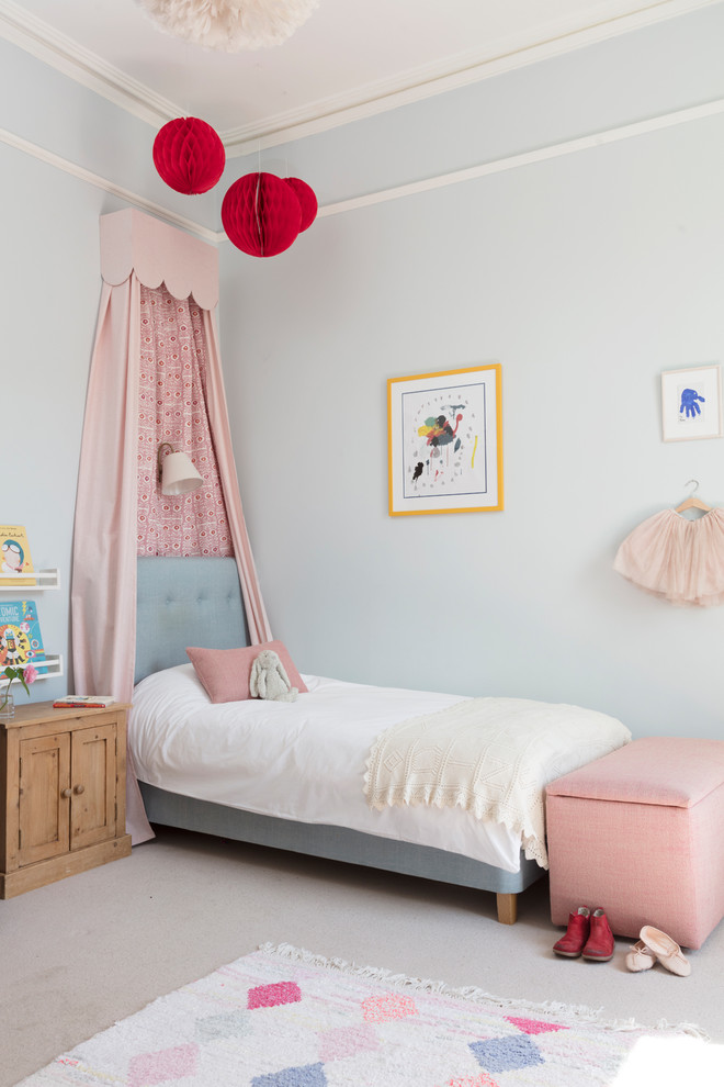 This is an example of a traditional children’s room for girls in Edinburgh with blue walls, carpet and beige floors.