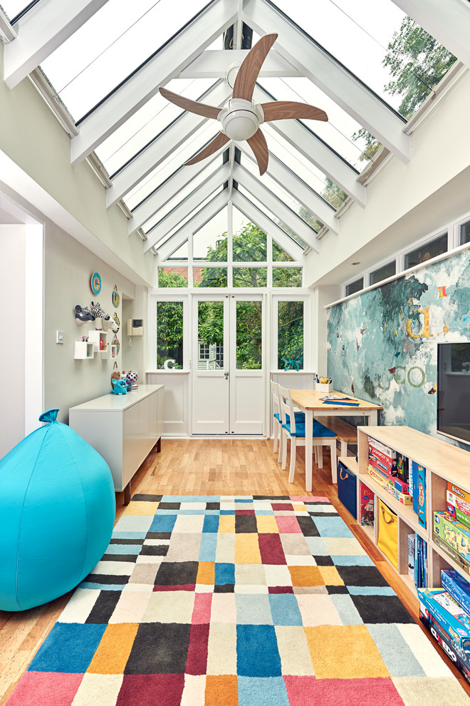 Modernes Jungszimmer mit Spielecke, grauer Wandfarbe und braunem Holzboden in London
