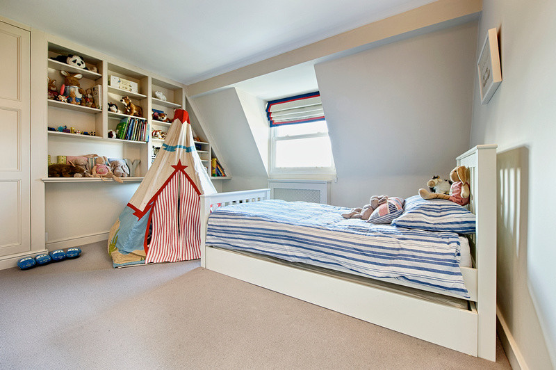 Photo of a medium sized traditional children’s room for boys in London with blue walls and carpet.