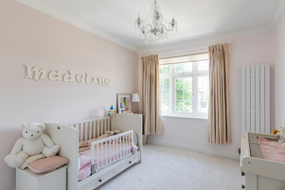 Modelo de dormitorio infantil de 1 a 3 años clásico de tamaño medio con paredes rosas, moqueta y suelo beige
