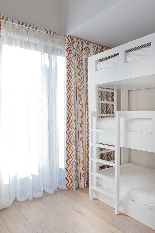 Exemple d'une chambre d'enfant chic avec un mur beige, parquet clair, un sol beige et un lit superposé.