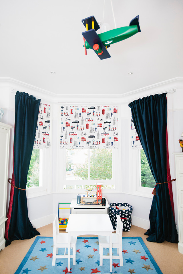 This is an example of a medium sized toddler’s room for boys in London with carpet.