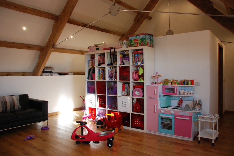 Diseño de dormitorio infantil de 1 a 3 años clásico de tamaño medio con paredes blancas y suelo de madera en tonos medios