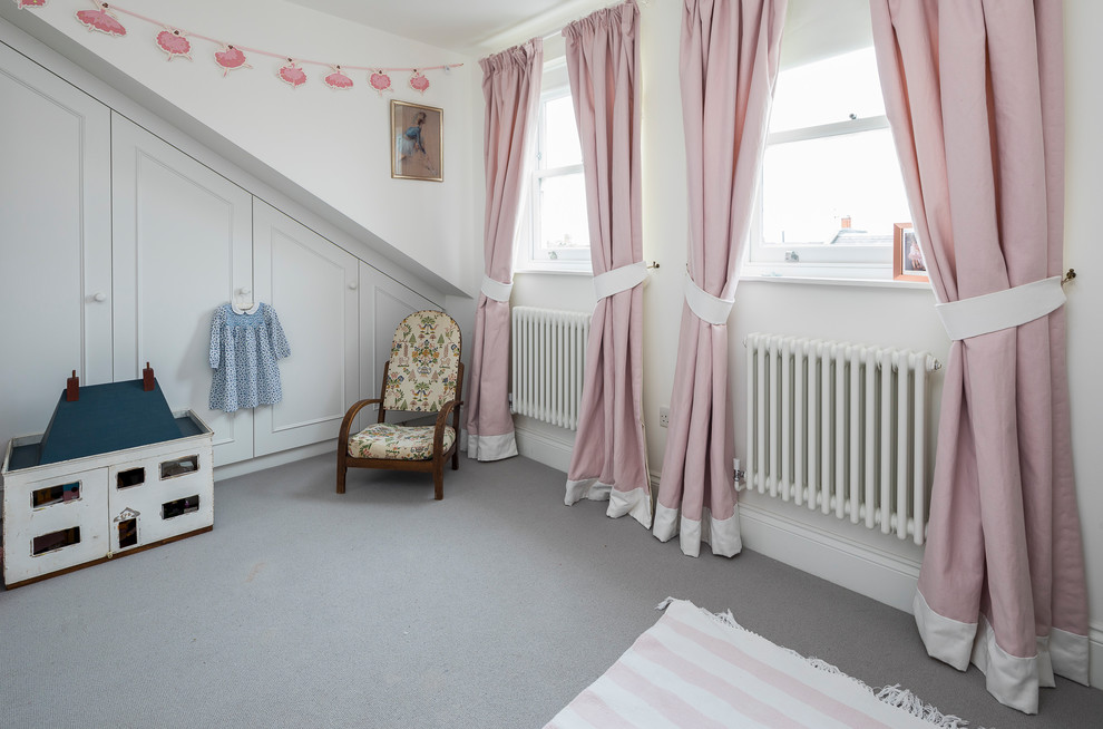 Immagine di una cameretta per bambini da 4 a 10 anni classica di medie dimensioni con pareti beige, moquette e pavimento beige