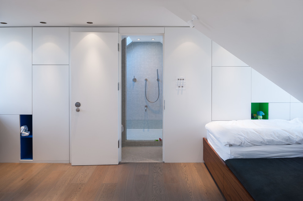 Photo of a small contemporary gender neutral children’s room in London with white walls and light hardwood flooring.