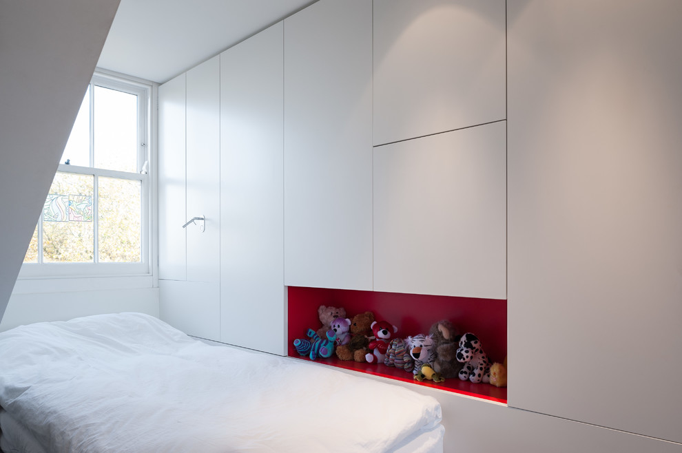 Small contemporary gender neutral children’s room in London with white walls and light hardwood flooring.