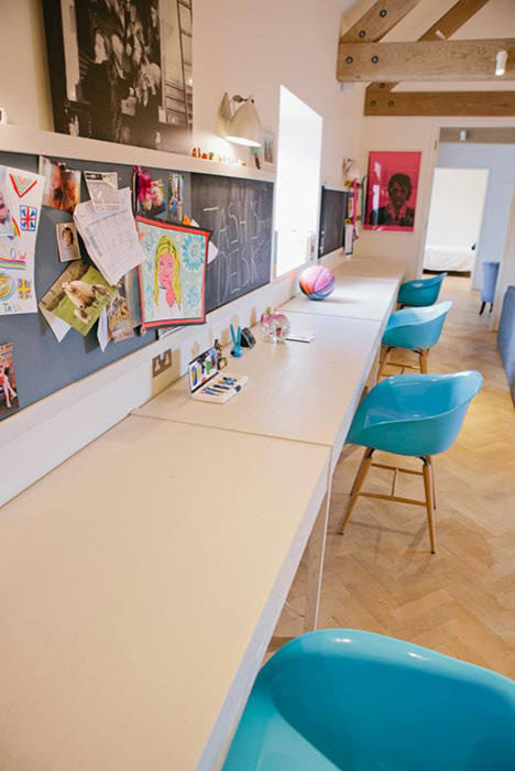 Example of a large trendy gender-neutral light wood floor kids' study room design in Devon with white walls