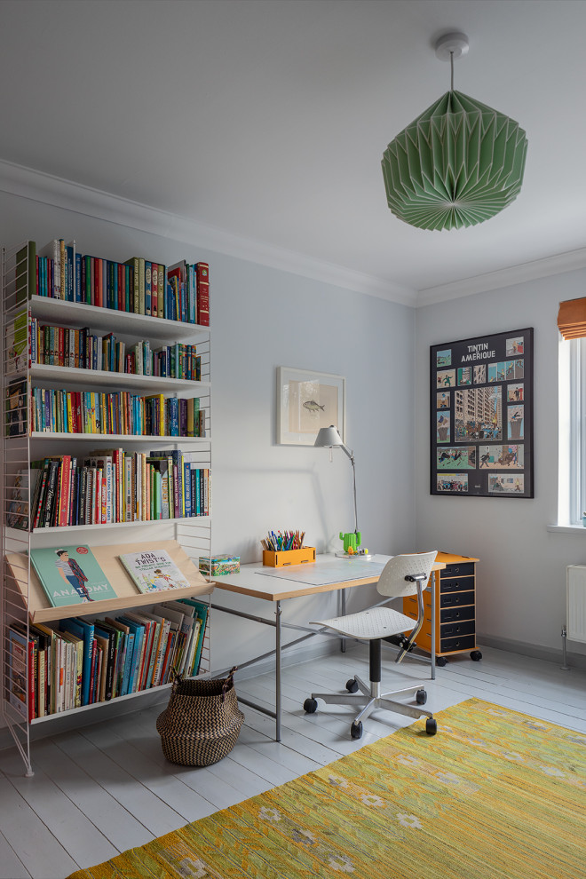 Ejemplo de habitación infantil unisex actual con escritorio, paredes grises, suelo de madera pintada y suelo gris