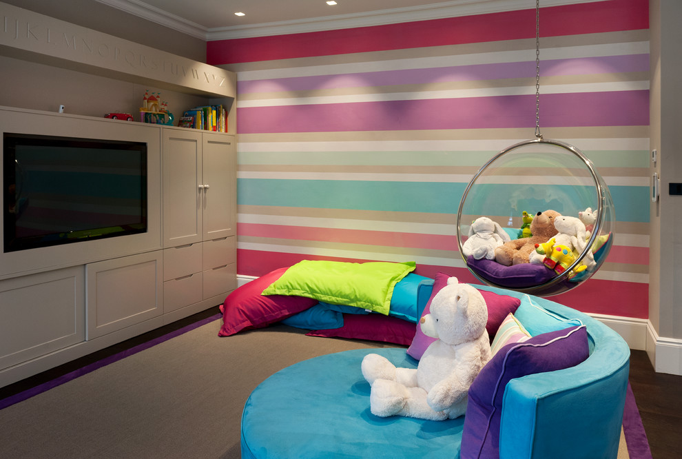 Cette photo montre une très grande chambre d'enfant de 4 à 10 ans tendance avec parquet foncé et un mur multicolore.