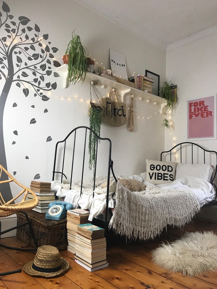 Idée de décoration pour une chambre de fille bohème avec un mur blanc, un sol en bois brun et un sol marron.