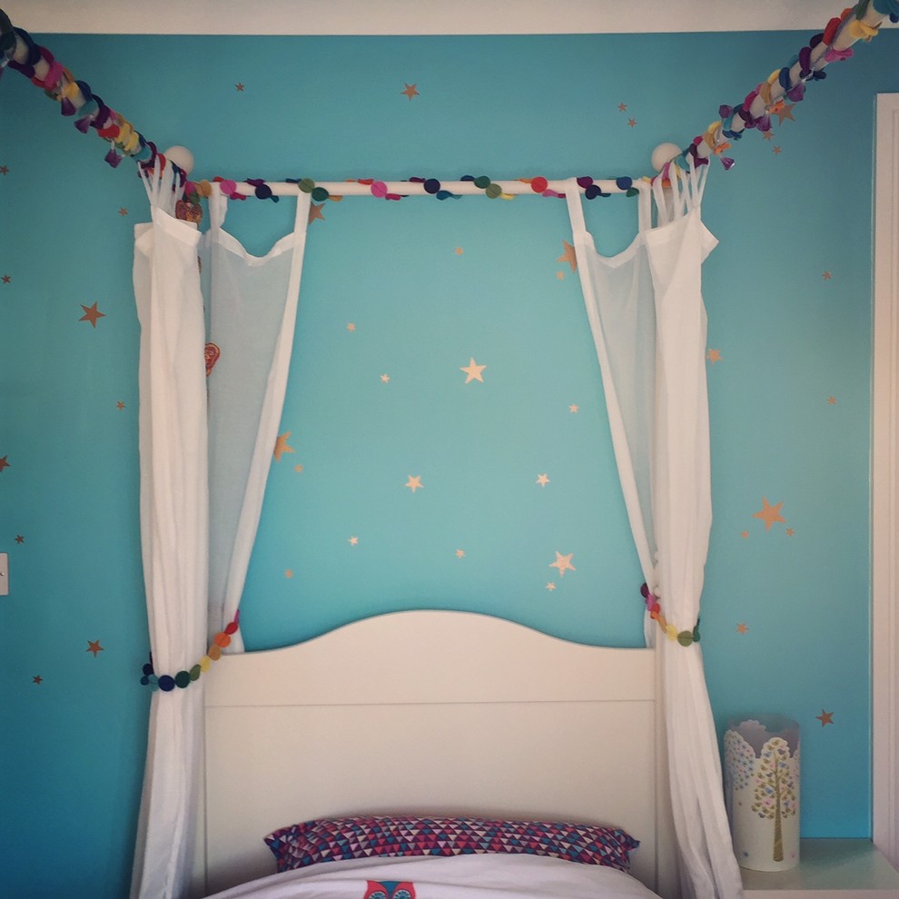 Immagine di una piccola cameretta per bambini da 4 a 10 anni design con pareti blu e parquet chiaro