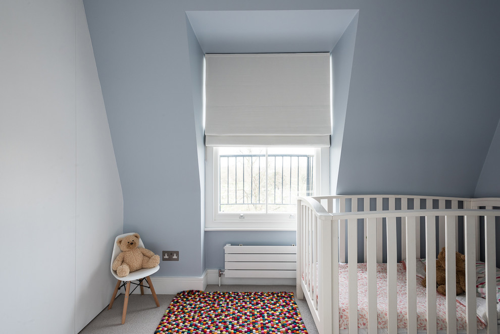 Esempio di una cameretta per neonata minimalista di medie dimensioni con pareti blu e moquette